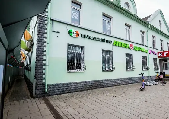 Зелёное трёхэтажное здание с вывесками